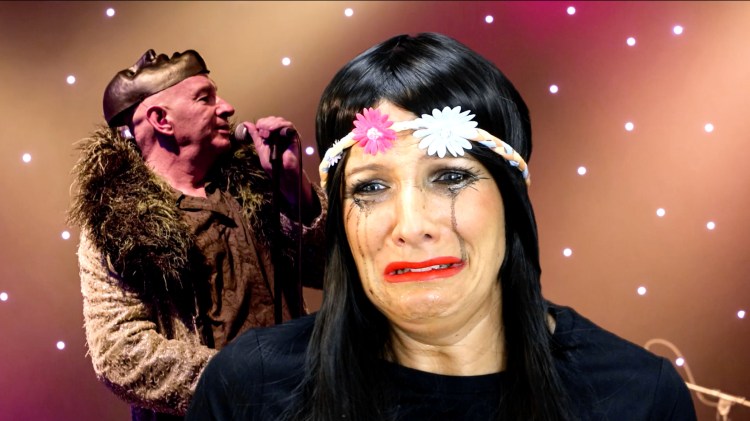 A woman wearing a floral headband cries in front of a greenscreened image of Brian Pern performing. Her make up is smeared from the tears.