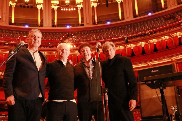 Four men on stage at the Royal Albert Hall.