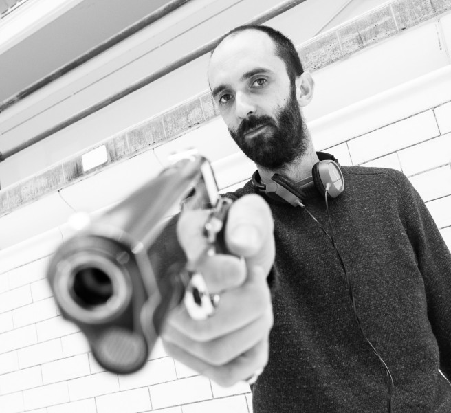 Director Dave Lambert poses with a gun.